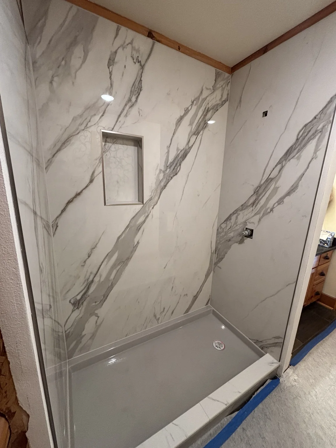 Large-format marble-look tile shower installation